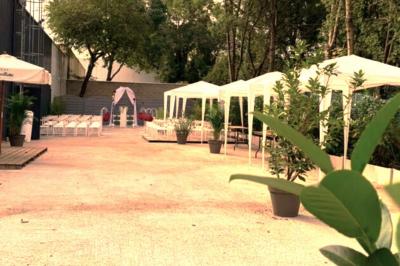 Cuisine professionnelle équipée avec four, réfrigérateur, plan de travail en inox et hotte d'extraction.