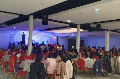 Cuisine professionnelle équipée avec four, réfrigérateur, plan de travail en inox et hotte d'extraction.