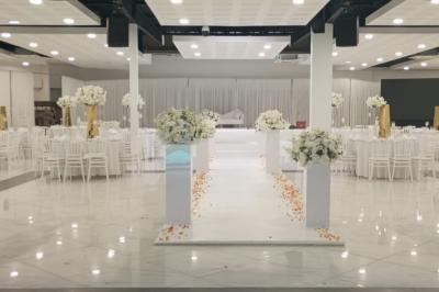 Cuisine professionnelle équipée avec four, réfrigérateur, plan de travail en inox et hotte d'extraction.