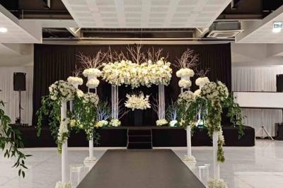 Cuisine professionnelle équipée avec four, réfrigérateur, plan de travail en inox et hotte d'extraction.