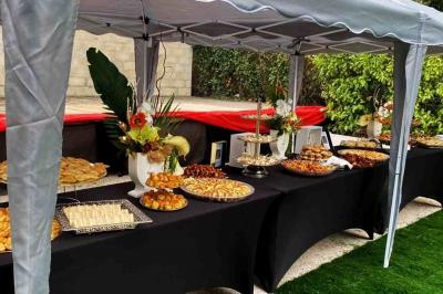 Cuisine professionnelle équipée avec four, réfrigérateur, plan de travail en inox et hotte d'extraction.