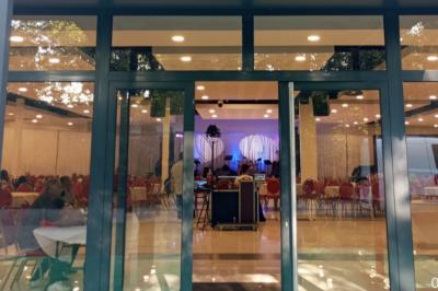 Cuisine professionnelle équipée avec four, réfrigérateur, plan de travail en inox et hotte d'extraction.