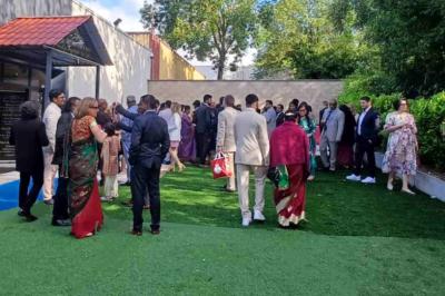 Cuisine professionnelle équipée avec four, réfrigérateur, plan de travail en inox et hotte d'extraction.