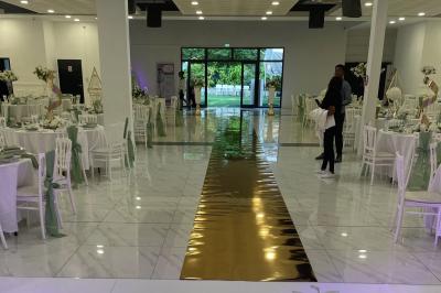 Cuisine professionnelle équipée avec four, réfrigérateur, plan de travail en inox et hotte d'extraction.