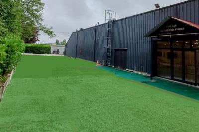 Cuisine professionnelle équipée avec four, réfrigérateur, plan de travail en inox et hotte d'extraction.