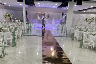 Cuisine professionnelle équipée avec four, réfrigérateur, plan de travail en inox et hotte d'extraction.