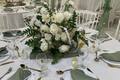 Cuisine professionnelle équipée avec four, réfrigérateur, plan de travail en inox et hotte d'extraction.