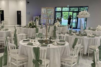 Cuisine professionnelle équipée avec four, réfrigérateur, plan de travail en inox et hotte d'extraction.