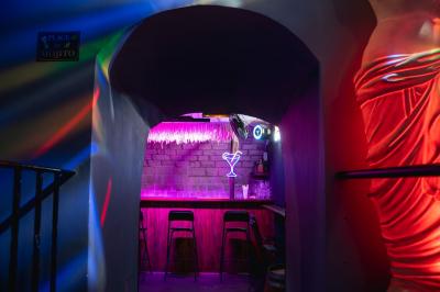 Écran de projection affichant une image d'intérieur coloré dans un espace sombre avec sièges et éclairage néon.