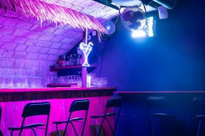 Écran de projection affichant une image d'intérieur coloré dans un espace sombre avec sièges et éclairage néon.