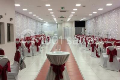 Miniature Location salle Bagnolet (Seine-Saint-Denis) - La Girafe #3 Salle décorée pour un événement avec tables rondes, nappes blanches, chaises ornées de nœuds argentés et dorés, éclairage…