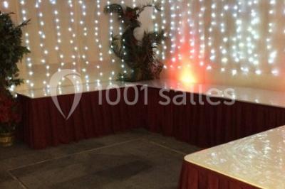 Miniature Location salle Bagnolet (Seine-Saint-Denis) - La Girafe #5 Salle décorée pour un événement avec tables rondes, nappes blanches, chaises ornées de nœuds argentés et dorés, éclairage…