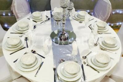 Miniature Location salle Bagnolet (Seine-Saint-Denis) - La Girafe #17 Salle décorée pour un événement avec tables rondes, nappes blanches, chaises ornées de nœuds argentés et dorés, éclairage…