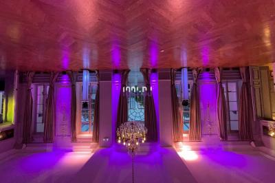 Des mariés avancent sous des étincelles tenues par des invités, entourés d'une foule prenant des photos.