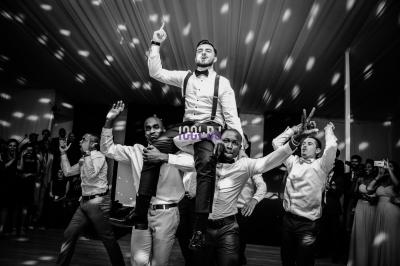 Des mariés avancent sous des étincelles tenues par des invités, entourés d'une foule prenant des photos.