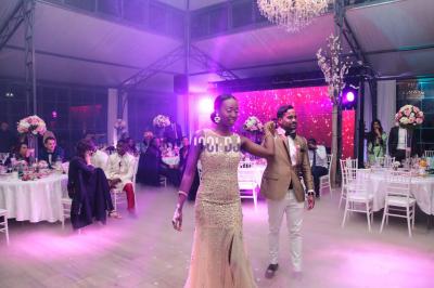 Des mariés avancent sous des étincelles tenues par des invités, entourés d'une foule prenant des photos.