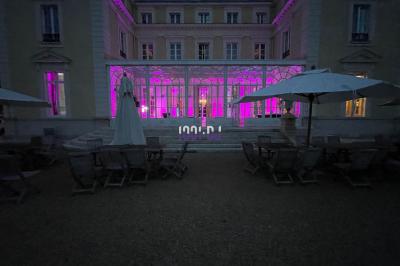 Des mariés avancent sous des étincelles tenues par des invités, entourés d'une foule prenant des photos.