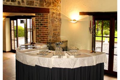 Parking en gravier entouré d'arbres et de bâtiments en briques sous un ciel partiellement nuageux.