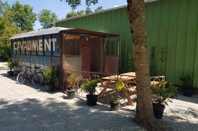 Coin salon avec canapé, fauteuils en cuir, table basse avec jeu d'échecs, bibliothèque et décorations murales.