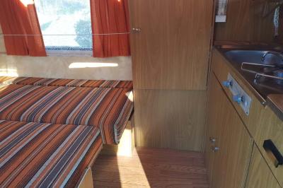 Coin salon avec canapé, fauteuils en cuir, table basse avec jeu d'échecs, bibliothèque et décorations murales.