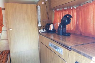 Coin salon avec canapé, fauteuils en cuir, table basse avec jeu d'échecs, bibliothèque et décorations murales.