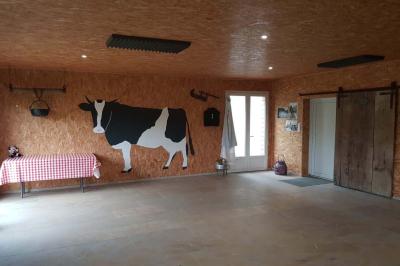 Coin salon avec canapé, fauteuils en cuir, table basse avec jeu d'échecs, bibliothèque et décorations murales.