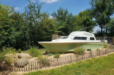 Coin salon avec canapé, fauteuils en cuir, table basse avec jeu d'échecs, bibliothèque et décorations murales.