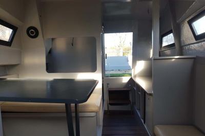 Coin salon avec canapé, fauteuils en cuir, table basse avec jeu d'échecs, bibliothèque et décorations murales.