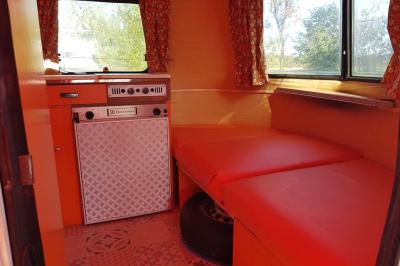 Coin salon avec canapé, fauteuils en cuir, table basse avec jeu d'échecs, bibliothèque et décorations murales.