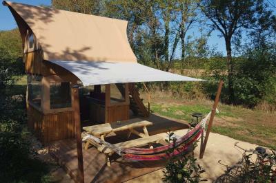 Coin salon avec canapé, fauteuils en cuir, table basse avec jeu d'échecs, bibliothèque et décorations murales.