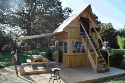 Coin salon avec canapé, fauteuils en cuir, table basse avec jeu d'échecs, bibliothèque et décorations murales.