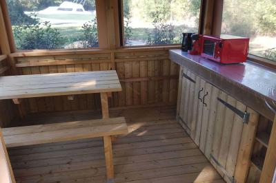 Coin salon avec canapé, fauteuils en cuir, table basse avec jeu d'échecs, bibliothèque et décorations murales.
