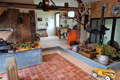 Coin salon avec canapé, fauteuils en cuir, table basse avec jeu d'échecs, bibliothèque et décorations murales.