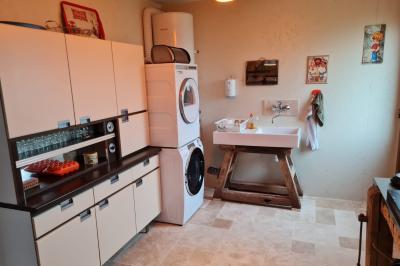 Coin salon avec canapé, fauteuils en cuir, table basse avec jeu d'échecs, bibliothèque et décorations murales.