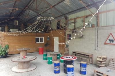 Espace de détente avec canapé, fauteuils, table basse avec échiquier, bibliothèque et décorations murales.