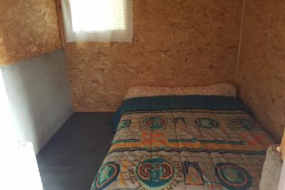 Espace de détente avec canapé, fauteuils, table basse avec échiquier, bibliothèque et décorations murales.