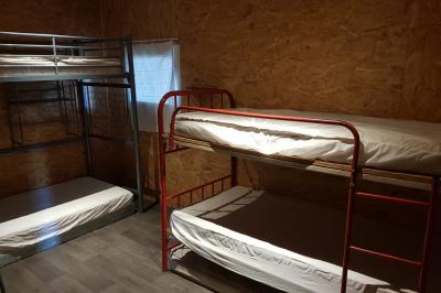 Espace de détente avec canapé, fauteuils, table basse avec échiquier, bibliothèque et décorations murales.