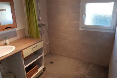 Espace de détente avec canapé, fauteuils, table basse avec échiquier, bibliothèque et décorations murales.