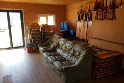 Espace de détente avec canapé, fauteuils, table basse avec échiquier, bibliothèque et décorations murales.