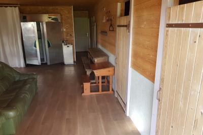 Espace de détente avec canapé, fauteuils, table basse avec échiquier, bibliothèque et décorations murales.