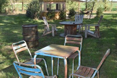 Espace de détente avec canapé, fauteuils, table basse avec échiquier, bibliothèque et décorations murales.