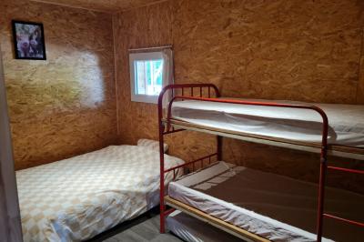 Espace de détente avec canapé, fauteuils, table basse avec échiquier, bibliothèque et décorations murales.