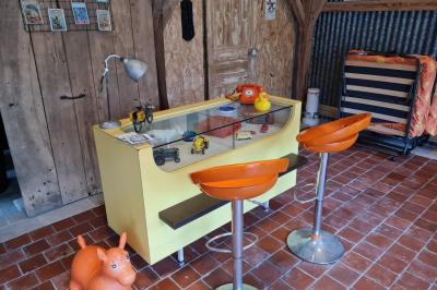 Espace de détente avec canapé, fauteuils, table basse avec échiquier, bibliothèque et décorations murales.