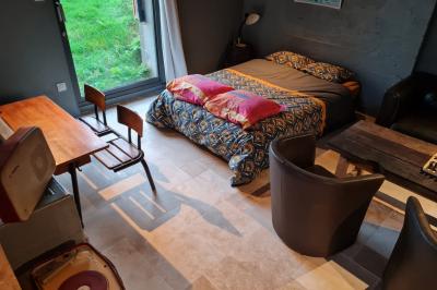 Espace de détente avec canapé, fauteuils, table basse avec échiquier, bibliothèque et décorations murales.