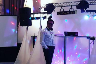 Table de mixage éclairée par des lumières colorées dans une ambiance de soirée ou de concert.