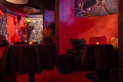 Deux femmes souriantes posent ensemble dans un environnement festif avec un éclairage tamisé.