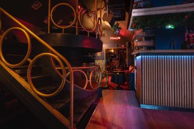 Deux femmes souriantes posent ensemble dans un environnement festif avec un éclairage tamisé.