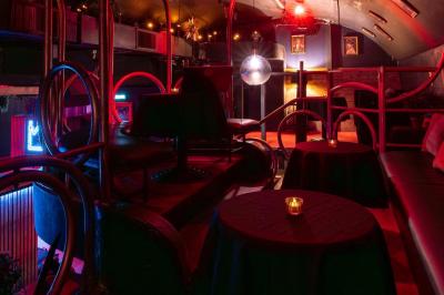 Deux femmes souriantes posent ensemble dans un environnement festif avec un éclairage tamisé.