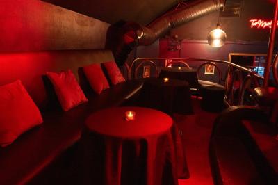 Deux femmes souriantes posent ensemble dans un environnement festif avec un éclairage tamisé.