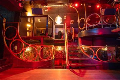 Deux femmes souriantes posent ensemble dans un environnement festif avec un éclairage tamisé.